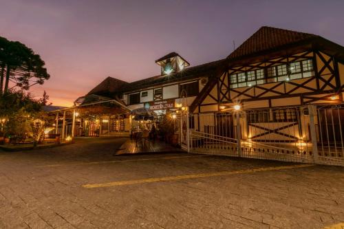 a large building with a gate in front of it at Pousada das Hortênsias in Campos do Jordão