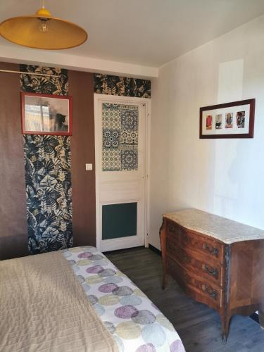 - une chambre avec un lit, une commode et une porte dans l'établissement Vue Mer à 20 mètres de la plage !, à Six-Fours-les-Plages