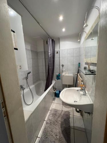 uma casa de banho com um lavatório, um chuveiro e uma banheira em Gemütlich eingerichtete 2-Zimmer Wohnung in Duisburg Meiderich em Duisburgo