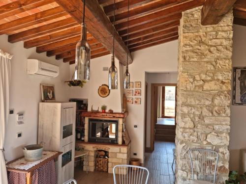 a living room with wooden ceilings and a stone wall at Podere I Ripidi in Vicchiomaggio