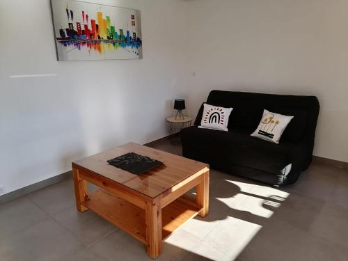 a living room with a black couch and a coffee table at les vignes in Villaz