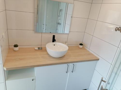 W łazience znajduje się biała umywalka i lustro. w obiekcie les vignes w mieście Villaz