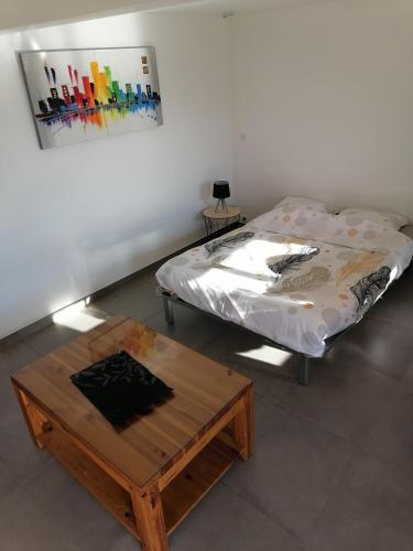 uma cama e uma mesa de centro num quarto em les vignes em Villaz