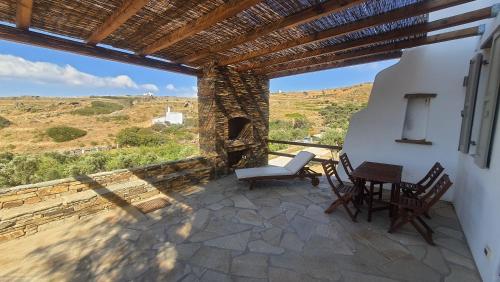 a patio with a table and chairs and a window at Tinos Retreat, Architect's Guest House in Tinos Town