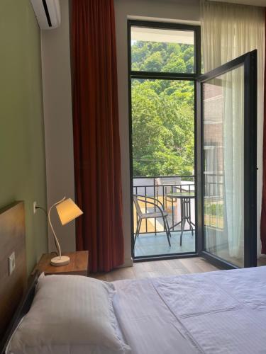 a bedroom with a bed and a view of a balcony at Villa Flora in Gonio