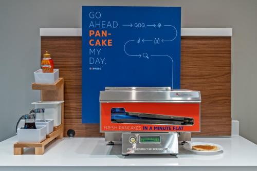 a kitchen with a pizza maker on a counter at Holiday Inn Express Hotel & Suites Woodbridge by IHG in Woodbridge