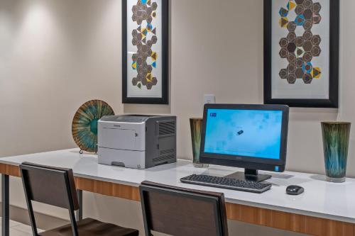a desk with a computer and a printer on it at Holiday Inn Express Hotel & Suites Woodbridge by IHG in Woodbridge