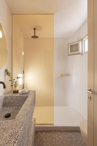 um banheiro com pia e chuveiro em Ethos Vegan Suites Fira, Santorini em Fira