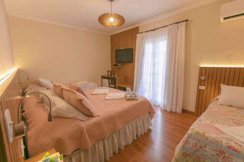 a bedroom with two beds and a window at Pousada das Hortênsias in Campos do Jordão