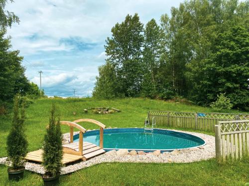 una pequeña piscina en un patio con terraza de madera en Dom caloroczny w Szymbarku, en Szymbark