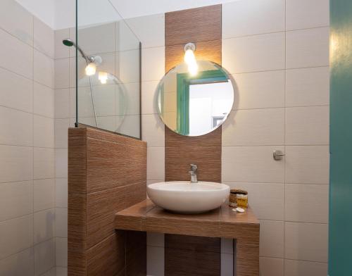 a bathroom with a sink and a mirror at Kochyli Beach Studios in Nea Plagia