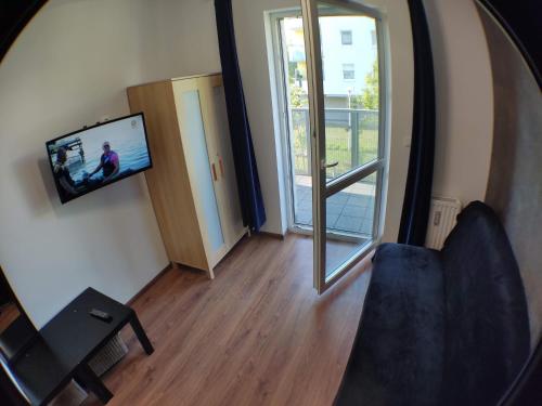 einen Spiegel, der ein Wohnzimmer mit einem TV an der Wand reflektiert in der Unterkunft 2110 Zwycięstwa 5N - Tanie Pokoje w Apartamencie - samodzielne zameldowanie - self check in in Posen