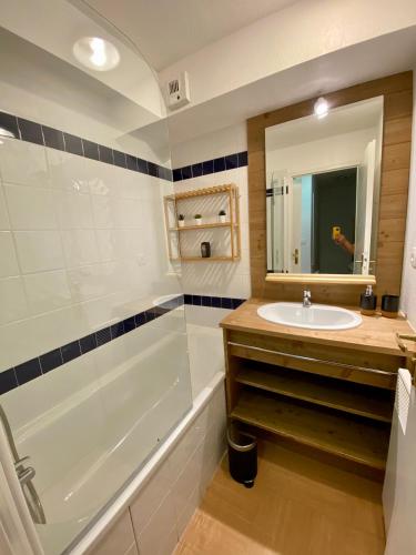 une salle de bain avec une baignoire, un lavabo et un miroir dans l'établissement Appartement 2 chambres vue pistes, parking privatif, aux Orres
