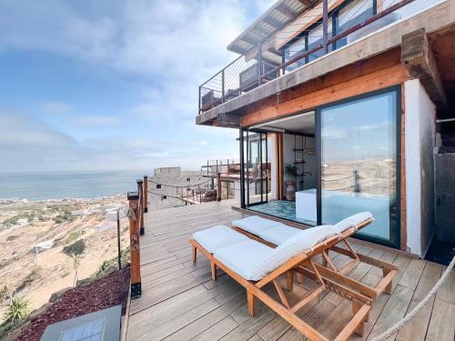 una terraza de madera con un banco y una piscina en Native Residence en Rosarito