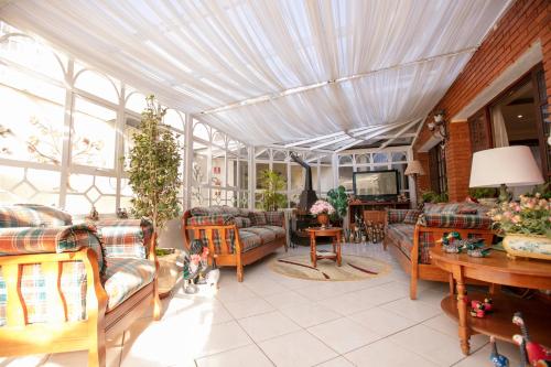 a living room with a conservatory with a ceiling at Pousada das Hortênsias in Campos do Jordão