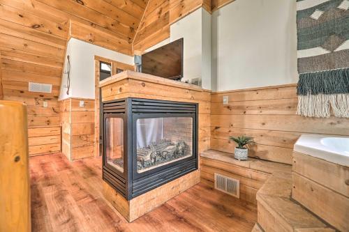 a living room with a fireplace in a log cabin at Cozy Retreat with Porch and Double JJ Resort Access! in Rothbury