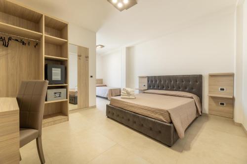 una camera con un letto e una televisione di Room Salento Palace 2 a Torre San Giovanni Ugento