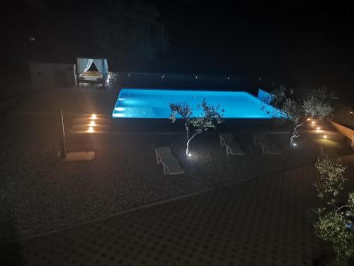 una piscina por la noche con 2 sillas en Large camper in the olive grove en Banjole