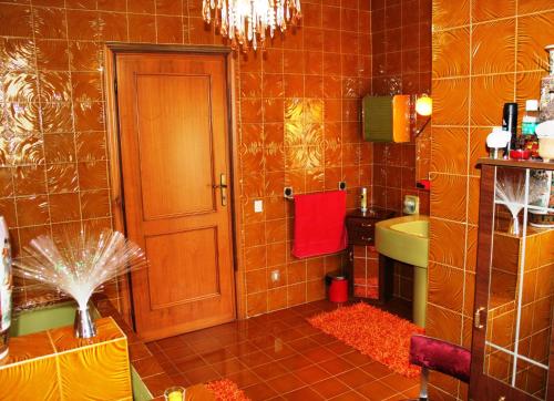 ProssediにあるAlturaのオレンジ色のタイル張りの壁のバスルーム(シンク付)