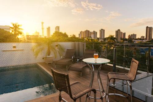 a balcony with a table and chairs and a pool at TuCasa Flats - Viva uma experiência de morador! in Foz do Iguaçu