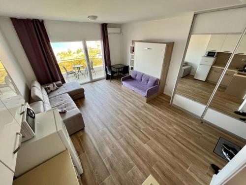 un soggiorno con un divano viola e una cucina di Apartments GC 3 a Rafailovici