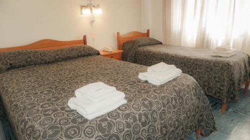 a hotel room with two beds with towels on them at HOTEL 3 DE ABRIL in Mar del Plata
