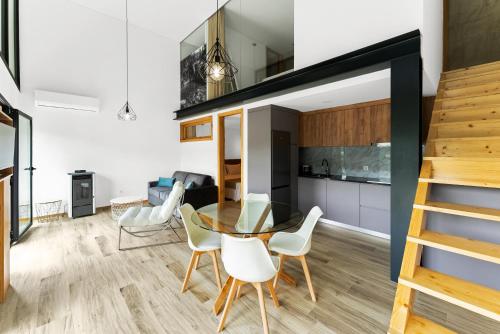 a kitchen and dining room with a glass table and white chairs at Gerês Villas in Geres