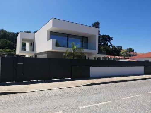 a white house with a black fence and a street at Casa de Ponte in Ponte de Lima