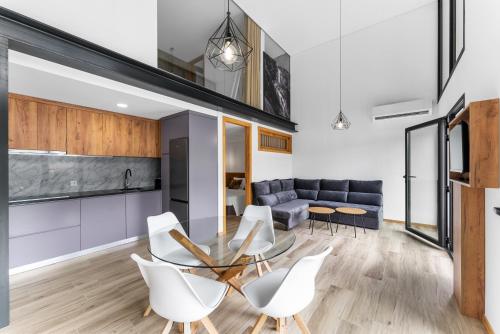 a living room with a glass table and white chairs at Gerês Villas in Geres
