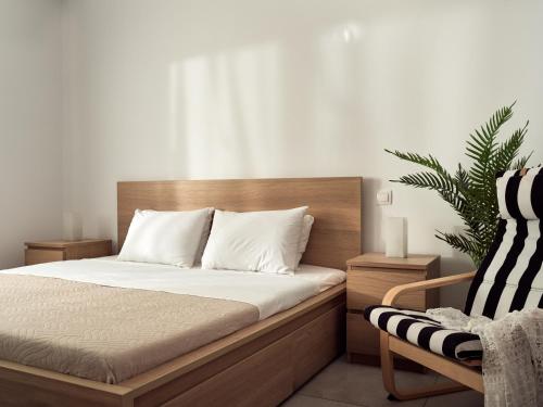 a bedroom with a bed and a chair and a plant at Margie City Apartment in Zakynthos