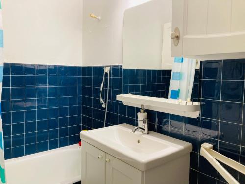 a blue tiled bathroom with a sink and a tub at Le ROS ÉDEN in Saint-Hilaire-de-Riez