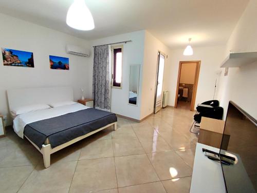 a bedroom with a bed and a tv in it at B&B Flavilla in Santa Flavia