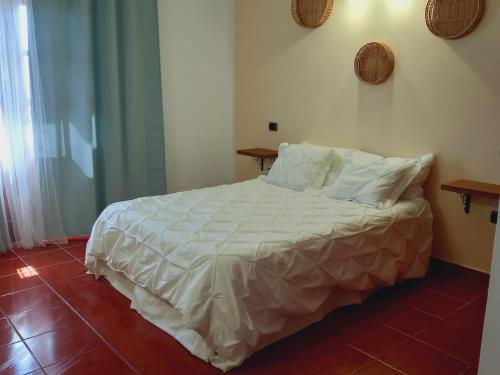 een slaapkamer met een groot bed met witte lakens en kussens bij CASA RAMOS II in Arrecife