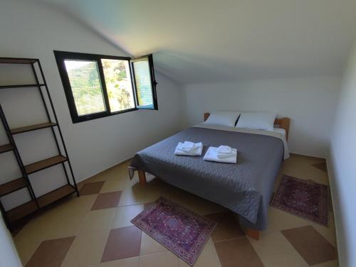 a bedroom with a bed with two towels on it at Montenegro Colors Kamenari in Kamenari