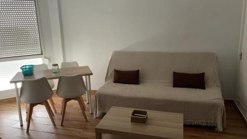 um pequeno quarto com uma cama, uma mesa e uma mesa; em Estudio cerca de la playa 3 em Málaga