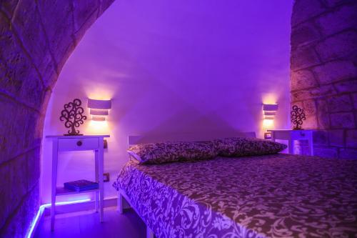a purple bedroom with a bed and two lamps at Ventidue Venti in Bari