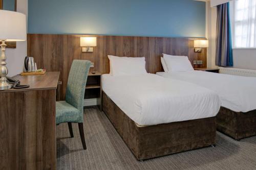 a hotel room with a bed and a desk and a chair at The Jephson Hotel; BW Signature Collection in Leamington Spa