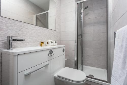 Marlborough Court - Donnini Apartments في آير: حمام مع مرحاض ومغسلة ودش
