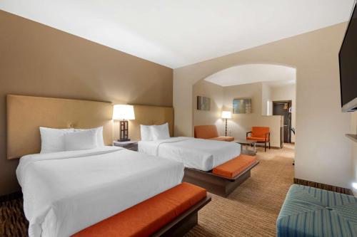 a hotel room with two beds and a living room at Best Western Plus DFW Airport Suites in Irving