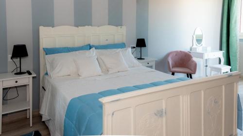 a bedroom with a white bed with blue and white pillows at Villa San Martino in Albiano dʼIvrea