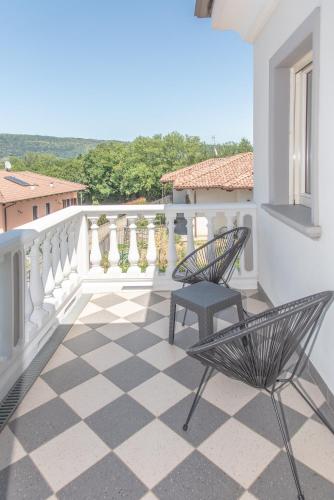 a balcony with two chairs and a checkered floor at Villa San Martino in Albiano dʼIvrea