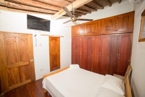 a bedroom with a bed and wooden cabinets at Casa Serrano - Callejón de Don Blas in Mompós