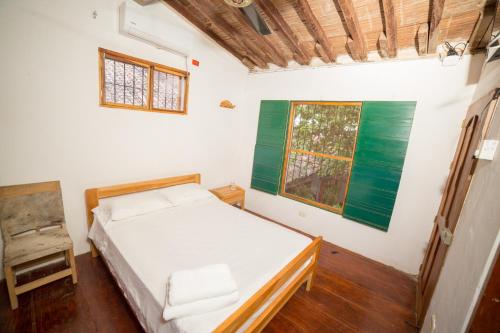 a small bedroom with a bed and a window at Casa Serrano - Callejón de Don Blas in Mompós