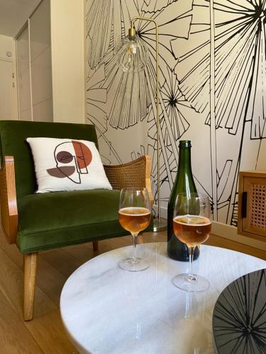 deux verres de vin sur une table avec une chaise verte dans l'établissement Le KEMPER - Cœur de ville, à Quimper