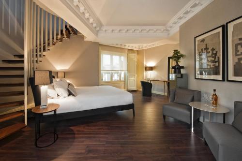 a bedroom with a bed and a staircase and a couch at Hotel Sardinero Madrid in Madrid