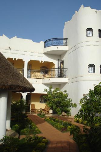 a large white building with balconies and trees at La Venise Malienne in Bamako