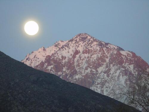 a snow covered mountain with the moon in the sky at Base Manzano in Tunuyán