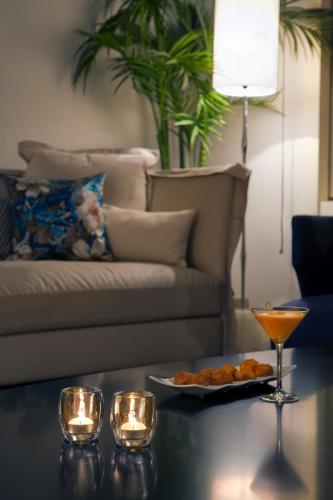 a living room with a couch and a table with a plate of food at Hotel Sardinero Madrid in Madrid