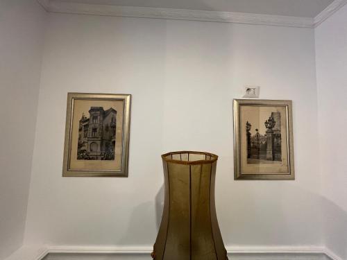 a vase in front of two pictures on a wall at Hotel Boutique Cathedral Plaza Residences room for rent downtown in Bucharest