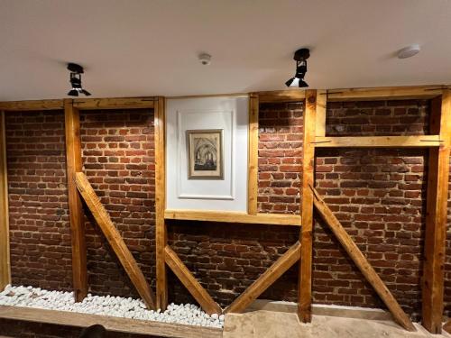 a brick wall with two wooden shelves at Hotel Boutique Cathedral Plaza Residences room for rent downtown in Bucharest
